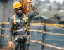 Un hombre con uniforme gris cargando cables