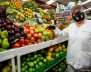 Mujer al lado de una despensa con frutas 