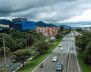 Carretera con pocos carros transitando y rodeada de árboles