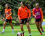 Tres mujeres vistiendo uniformes naranjas