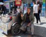 Un hombre al lado de un carro metálico