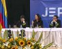 Jueces de la JEP sentados en una mesa blanca