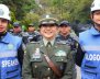 Mujer vestida de policía en el centro con dos mujeres con chalecos azules y cascos blancos a los lados