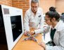 Alumno y profesora con batas de laboratorio 