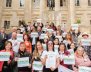 Mujeres paradas enfrente de la Casa de Nariño con carteles en las manos