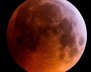 Foto de una luna llena toda de color rojo, sobre un fondo negro