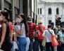 Personas haciendo fila con carpetas en las manos