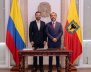 Dos hombres de traje detrás de una mesa de madera