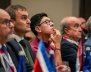 Cinco hombres sentados mirando fijamente hacia el frente