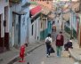 Una calle con casas a los lados y personas caminando 