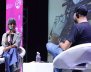 Mujer y hombre conversando sentados en una tarima