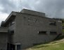 Facha de un colegio: un edificio gris con ventanas de marco rectangular