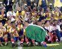 Equipo de fútbol con camisetas amarillas celebrando