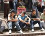 Jóvenes sentados en una acera hablando