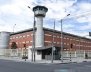 Cárcel de ladrillos, con rejas metálicas y un torreón en el centro 