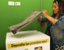 Mujer dobla una muda de ropa sobre una de las cajas dispuestas para las donaciones