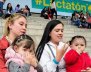 Dos mujeres con niñas alzadas en las rodillas estando en una escalera.