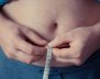 Hombre midiéndose el diámetro de la cintura con una cinta métrica