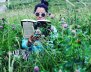 Lala Ocampo leyendo en medio de plantas 