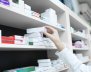 Personas acomodando medicamentos en un a estantería 