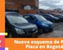 En la imagen se pueden ver varios carros en fila en un parqueadero de Bogotá durante el día. 