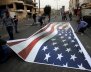 Palestinian demonstrators place on the ground a representation of a U.S. flag during a protest in the West Bank city of Bethlehem