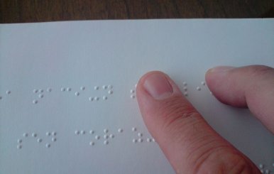1024px-A_person_reading_a_braille_book