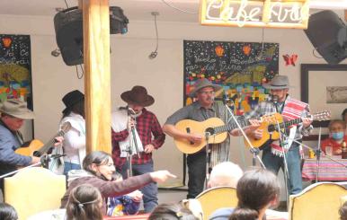 Artistas sobre una tarima con guitarras en la mano 