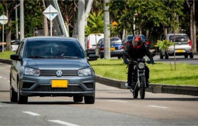 Carro gris y moto negra sobre la carretera