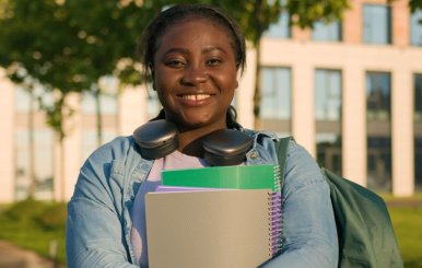 Mujer sonriente con cuadernos en sus manos