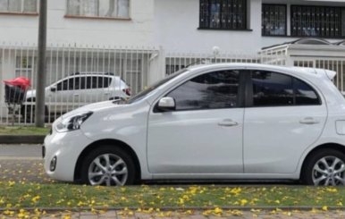 Automóvil blanco parqueado en una acera 