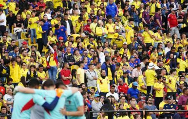 Tribuna del estadio El Campín con aficionados con camisetas amarillas