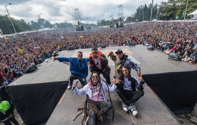 Un grupo de Hip Hop sobre una tarima. Al frente una gran multitud de personas