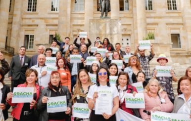 Mujeres paradas enfrente de la Casa de Nariño con carteles en las manos