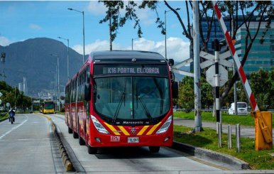 Bus rojo de TransMilenio sobre la calle