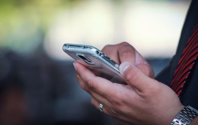 Un hombre sosteniendo un celular en su mano