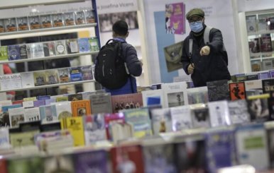 Dos personas caminando por pasillos llenos de libros