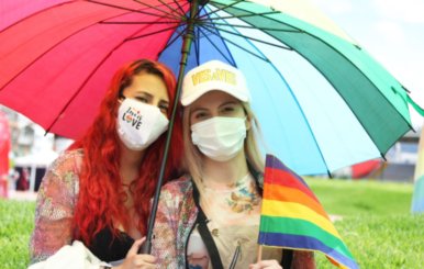 Dos mujeres bajo una sombrilla de colores