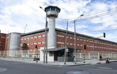 Cárcel de ladrillos, con rejas metálicas y un torreón en el centro 