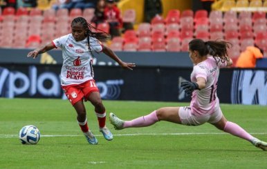 Imagen de una jugadora de Santa Fe contra una portera rival en la Copa Libertadores Femenina 2023