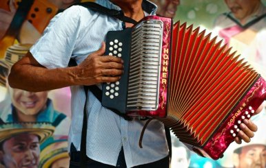 Hombre con un acordeón extendido en el pecho