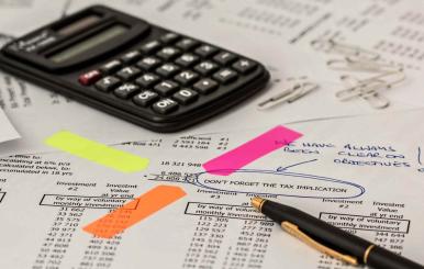 Calculadora sobre hojas con cuentas y números 