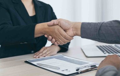 Dos adultos apretando sus manos en referencia de un trato 