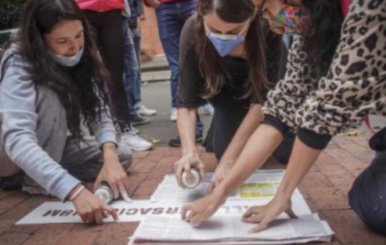 Imagen de referencia de mujeres escribiendo un letrero. 