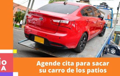 Carro rojo siendo recogido por una grúa de tránsito.