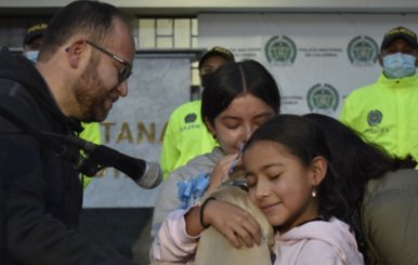 Niña abraza al perrito en presencia de la Policía Metropolitana de Bogotá
