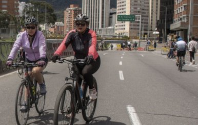 Mujeres en bicicleta recorriendo una de las vías principales de la ciudad durante la ciclovía