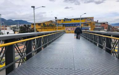 Persona caminando por uno de los puentes peatonales de TransMilenio 