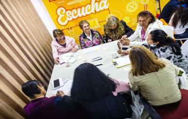 Adultos mayores reunidos en una mesa dialogando 