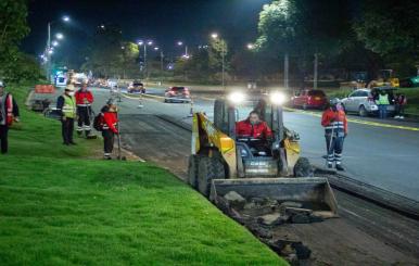 Personas trabajando en horas de la noche sobre la avenida de la calle 170 